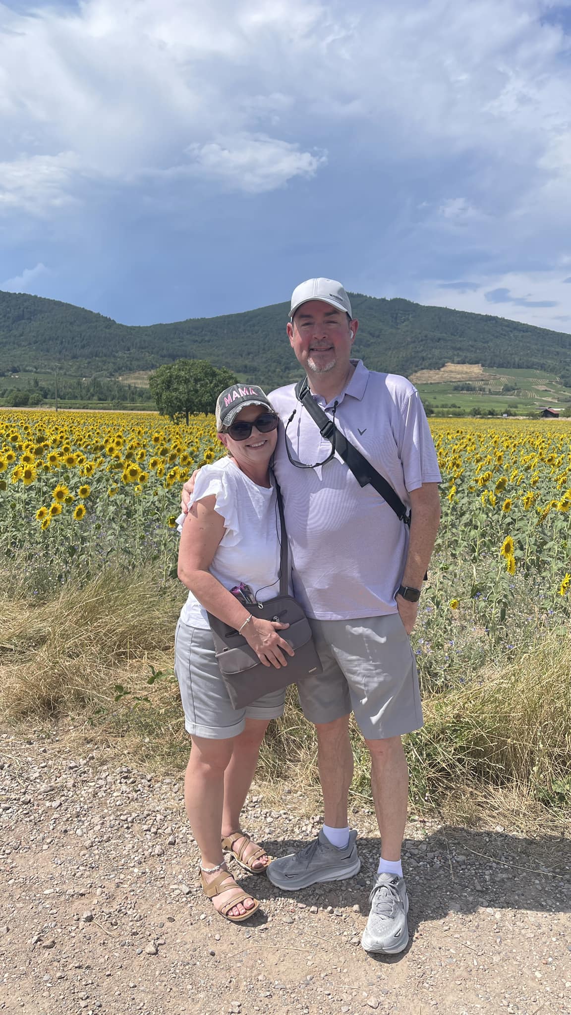 a couple standing in front of sunflowers in France